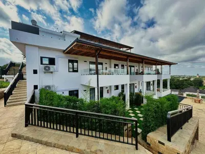a large white house with a balcony on top of it at Moshono Hillside in Arusha