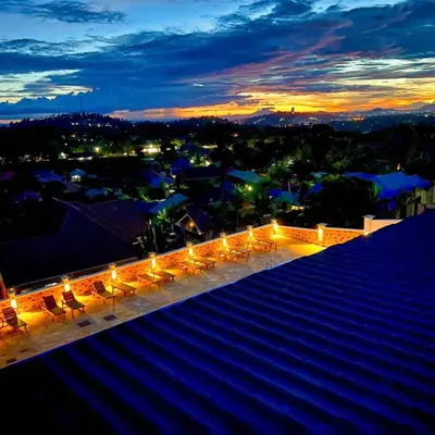 a rooftop patio with chairs and lights at night at Moshono Hillside in Arusha