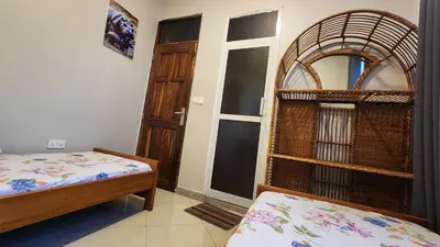 a room with two beds and a room with a door at Pembeni River House in Arusha