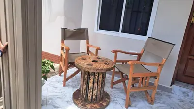 a group of chairs and a table on a porch at Pembeni River House in Arusha