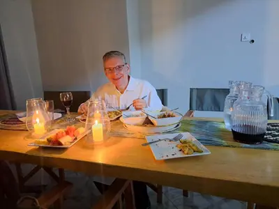 a man sitting at a table with a plate of food at Pembeni River House in Arusha