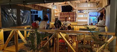 a group of people sitting at a bar at Pembeni River House in Arusha