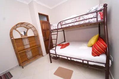 a bedroom with two bunk beds and a mirror at Pembeni River House in Arusha