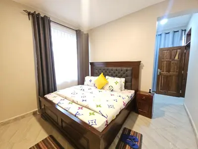 a bedroom with a bed and a window at Pembeni River House in Arusha