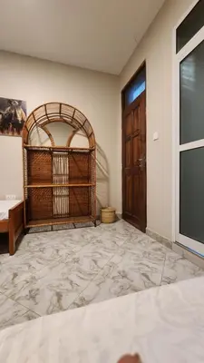 a room with a bed and a window and a door at Pembeni River House in Arusha