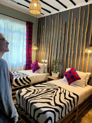 a person standing in a room with two beds at Villa Rosa in Moshi