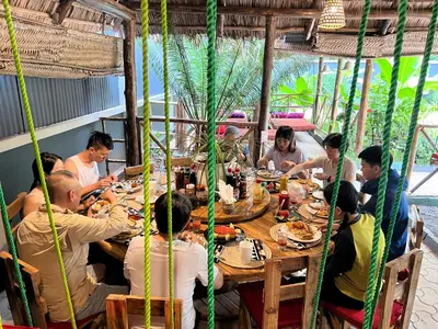 a group of people sitting at a table eating food at Villa Rosa in Moshi