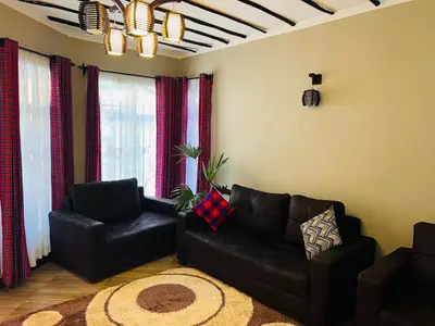 a living room with a couch and a chair at Villa Rosa in Moshi