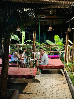 a group of people sitting on benches in a hut at Villa Rosa in Moshi
