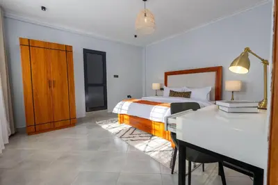 a bedroom with a bed and a desk in it at Serenita Homes Arusha in Arusha