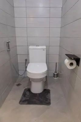 a bathroom with a white toilet in a stall at Serenita Homes Arusha in Arusha