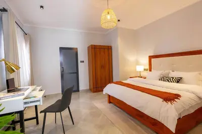 a bedroom with a bed and a desk and a computer at Serenita Homes Arusha in Arusha