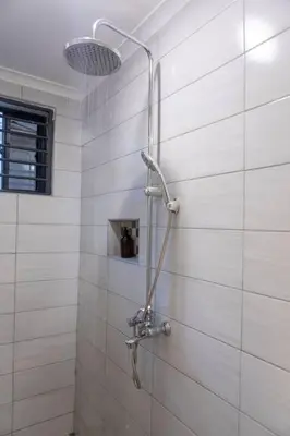 a shower with a shower head in a bathroom at Serenita Homes Arusha in Arusha