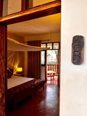 a bedroom with a bunk bed and a chair at Kilimanjaro Lodge - MCF in Moshi