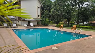 a swimming pool in front of a house at Kilimanjaro Lodge - MCF in Moshi
