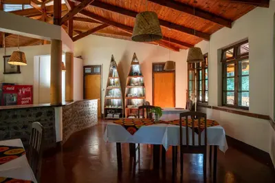 a dining room with a table and two christmas trees at Kilimanjaro Lodge - MCF in Moshi