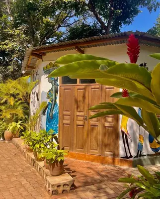 a building with a wooden door with a painting on it at Kilimanjaro Lodge - MCF in Moshi