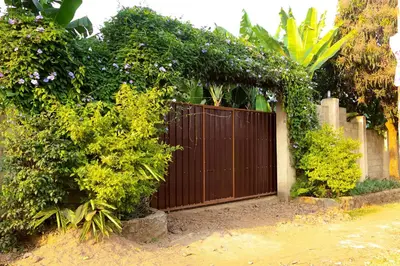 a wooden gate in a garden with plants at Mama Ket Homes Apartment in Arusha