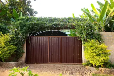 a wooden gate in a garden with plants at Mama Ket Homes Apartment in Arusha