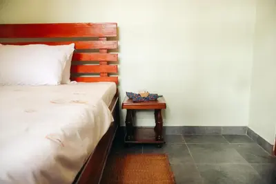 a bedroom with a bed and a night stand next to a table at Mesa Home Apartment in Arusha