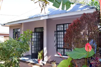 a small house with a blue roof at Mesa Home Apartment in Arusha