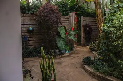 a garden with a wooden fence and some plants at Mesa Home Apartment in Arusha