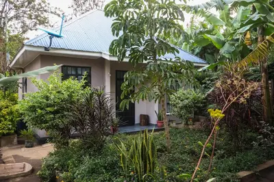 a house in the middle of a garden at Mesa Home Apartment in Arusha