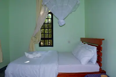a bedroom with two beds and a window at Mesa Home Apartment in Arusha