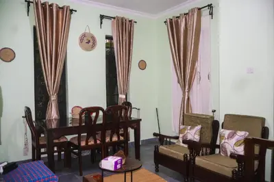 a living room with a table and chairs at Mesa Home Apartment in Arusha