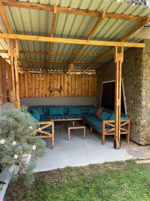 a wooden pergola with a bench and a table at Casa Mianzini in Arusha