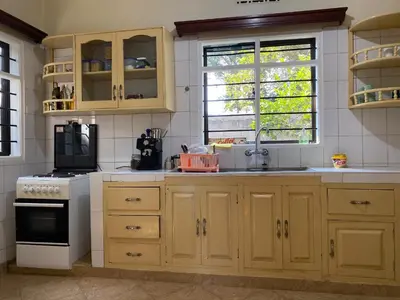 a kitchen with wooden cabinets and a stove top oven at Casa Mianzini in Arusha