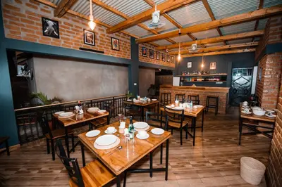 a restaurant with wooden tables and chairs in a room at Katiti Lodge in Arusha