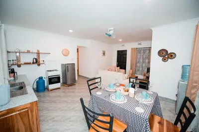 a kitchen and living room with a table and chairs at Katiti Lodge in Arusha