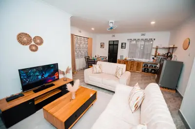 a living room with a couch and a tv at Katiti Lodge in Arusha