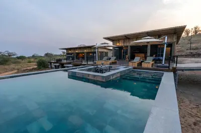 a house with a swimming pool in front of a building at Tarangire Elephant Springs in Engassumet