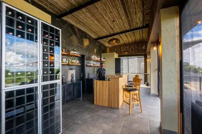 a man standing at a bar in a wine tasting room at Tarangire Elephant Springs in Engassumet