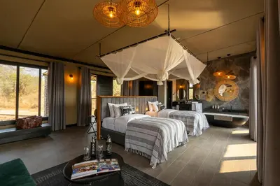 a bedroom with two beds and a tub in a room at Tarangire Elephant Springs in Engassumet