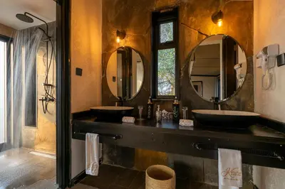 a bathroom with two sinks and two mirrors at Tarangire Elephant Springs in Engassumet