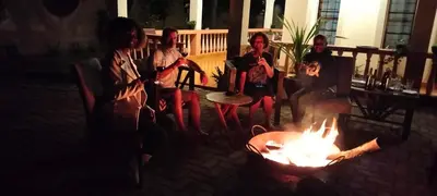 a group of people sitting around a fire pit at Hansat Homestay Residence in Arusha