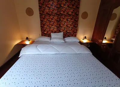 a bedroom with a large white bed with two lamps at Hansat Homestay Residence in Arusha