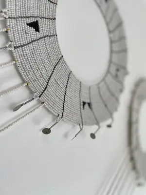 a white ceiling with a necklace and a mirror at Ndani House in Arusha