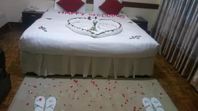 a bedroom with a bed with a bride and groom cake at The Charity Hotel International in Arusha