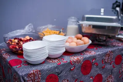 a table with plates and a bowl of eggs at Hecasa Apartments in Arusha