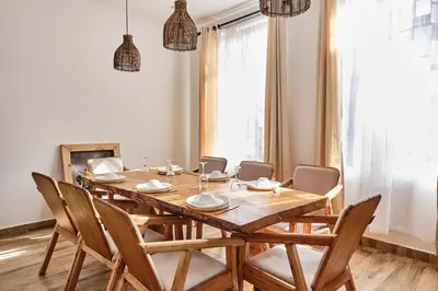 a dining room with a wooden table and chairs at Elmitho House in Arusha