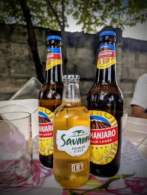 three bottles of beer sitting on a table at Lasts minute lodge in Boma la Ngombe