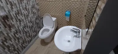 a bathroom with a white toilet and a sink at Lasts minute lodge in Boma la Ngombe