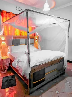 a bed with a canopy in a room at karibu la kossa in Tuvaila