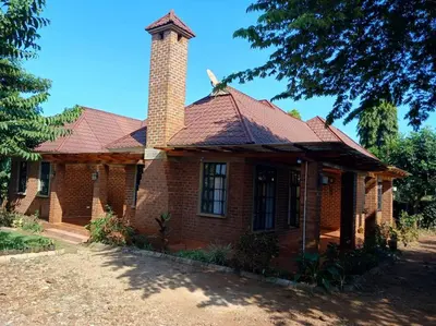 a brick house with a chimney on top of it at Rau River House - Moshi in Msaranga