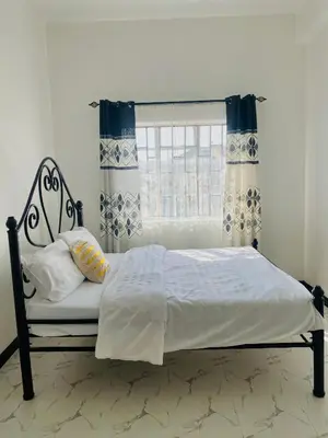 a bed in a bedroom with a window at Maya in Arusha