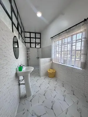 a white bathroom with a sink and a mirror at Maya in Arusha